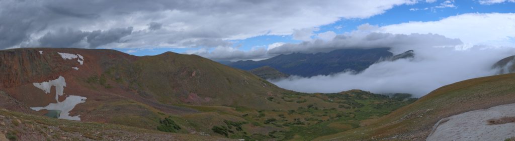 View is eastward from near the summit. Estes Park is hidden in the centre left of the picture. A small glacier (really just packed snow) is seen to the right of the image. Note the clouds in the centre right of the image below elevation of the camera. The road passed through this cloud -- visibility was poor!